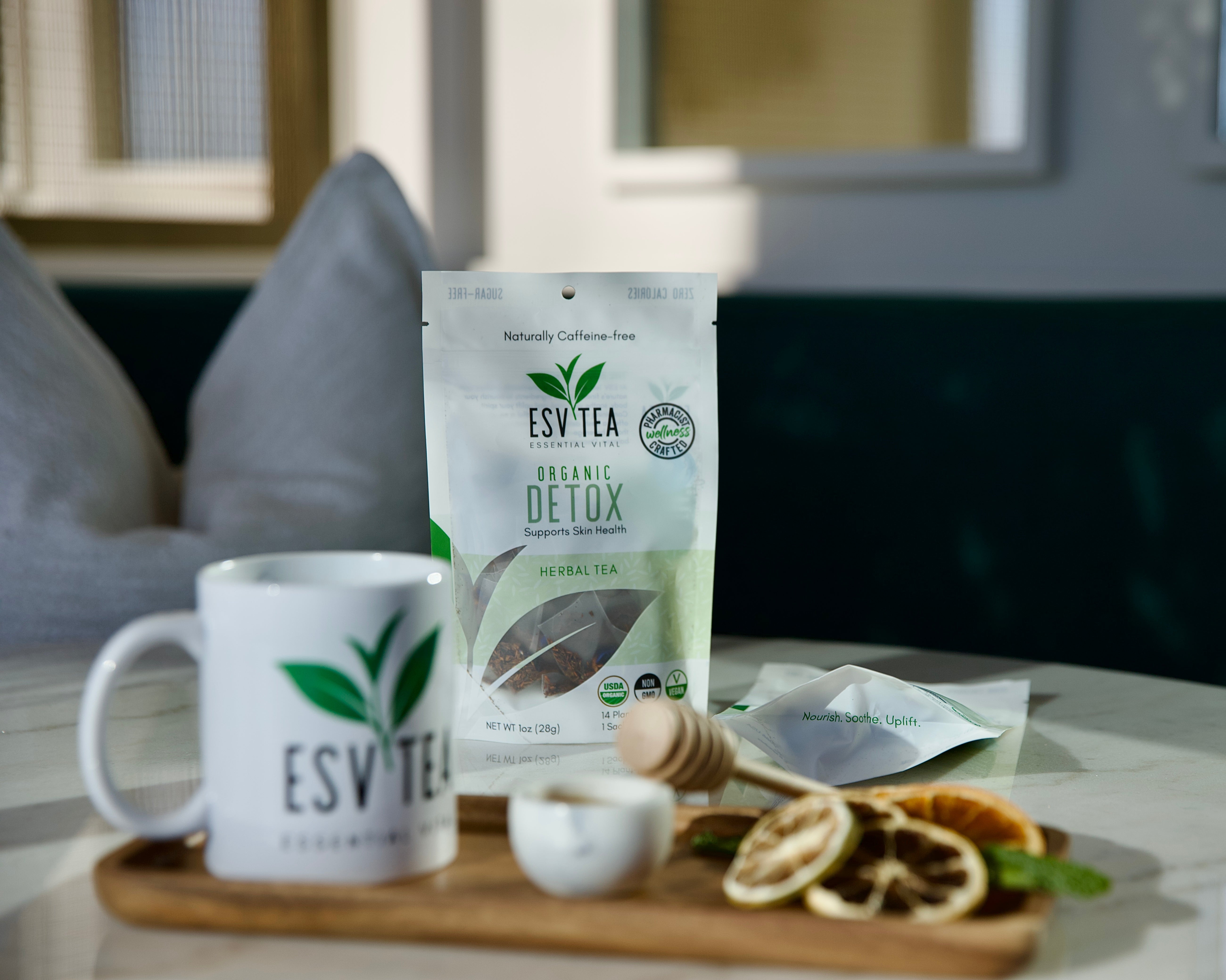 ESV Tea Organic Detox package on a table with a mug and tea leaves.